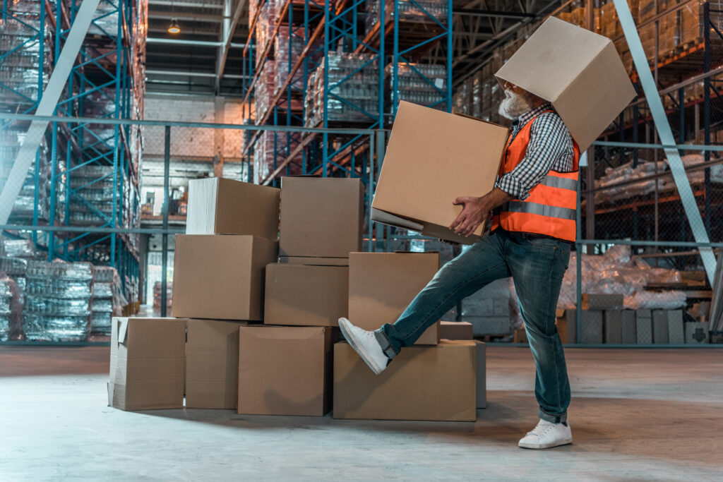 Man carrying blank cardboard boxes in a warehouse
