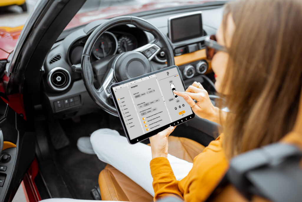 A woman controlling a car's systems from a tablet